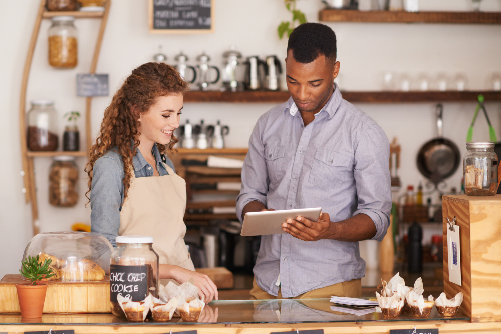 Small restaurant operators looking at iPad at counter.