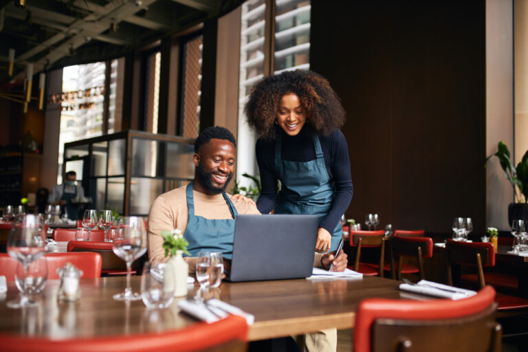 Restaurant managers working with laptop figuring out the restaurant prime cost