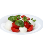 Caprese salad in a bowl isolated on white background - produce commodity update from back office