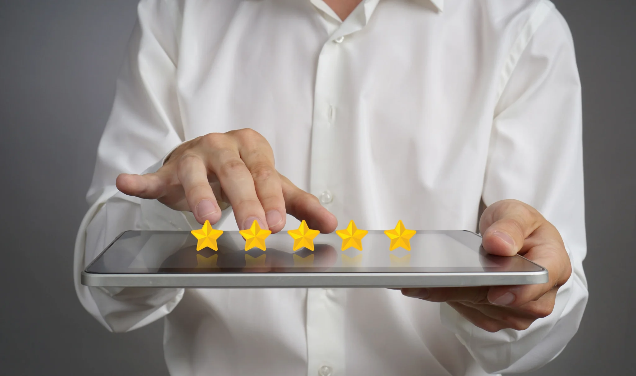 Hands tapping a five-star rating on a tablet.