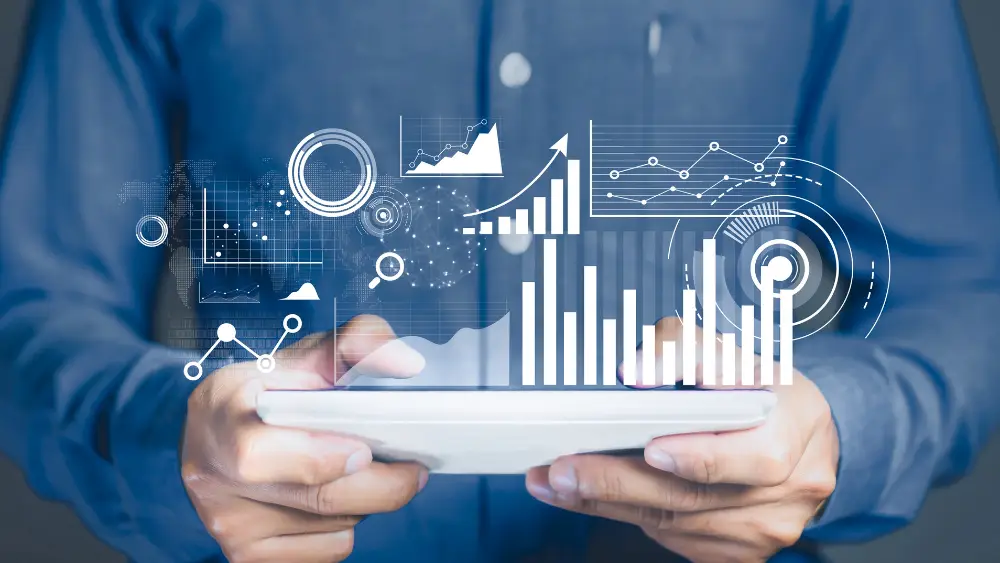 Hands holding tablet with floating graphs