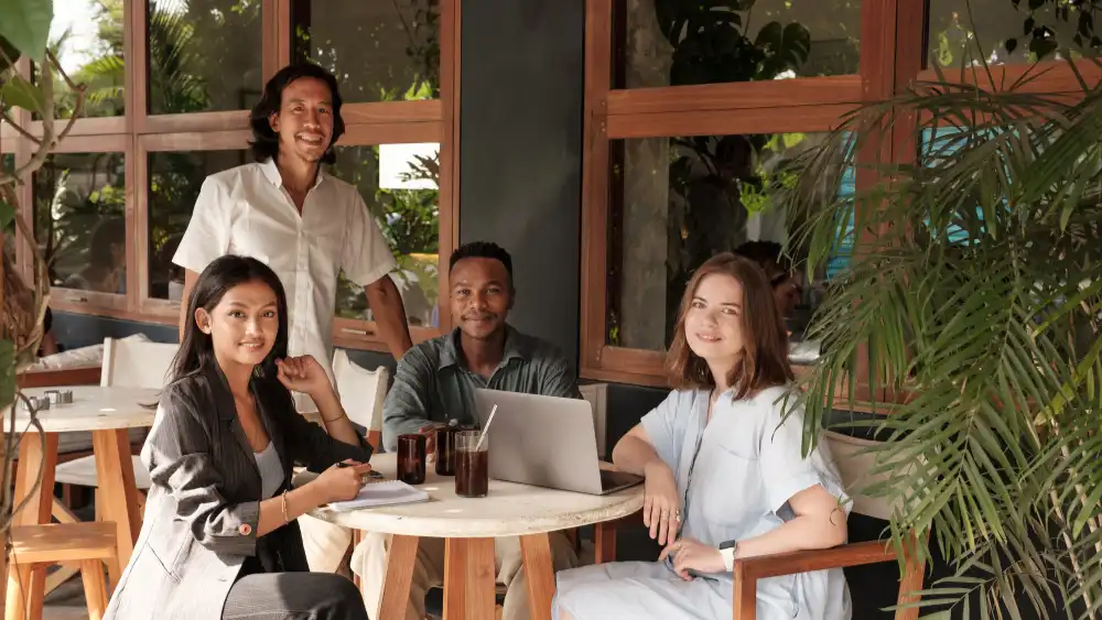 Restaurant Owners Smiling At Camera in Empty Restaurant with Laptop