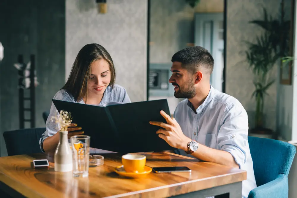 A happy young couple looking at a menu at a restaurant
