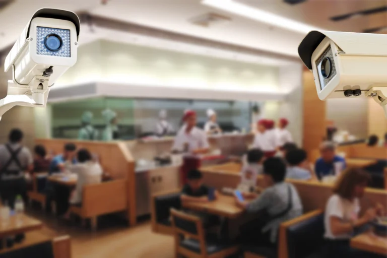 Close-up of security cameras monitoring a busy restaurant, highlighting loss prevention