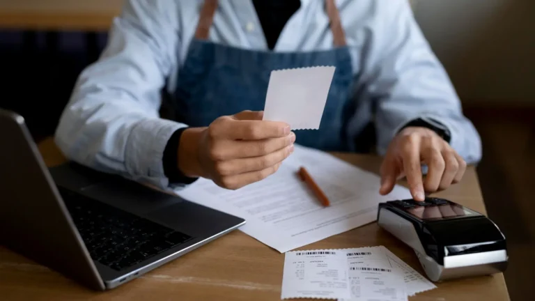 Restaurant Operator Reviewing Receipts and Financial Records at Desk