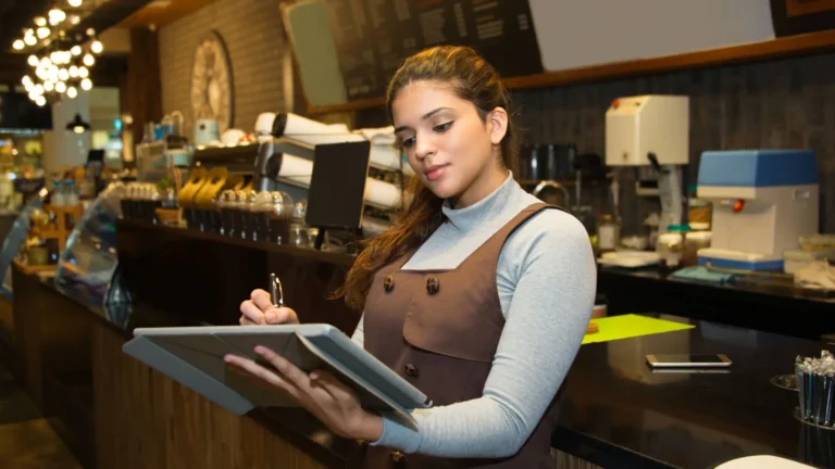 Restaurant employee reviewing financial reports at the counter of a multi-unit restaurant