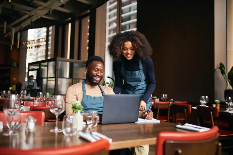 Restaurant managers working with laptop figuring out the restaurant prime cost