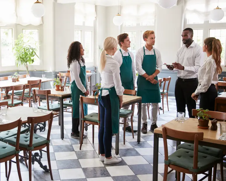Manager and team discussing restaurant labor cost