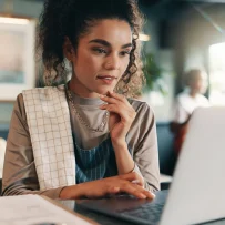 Restaurant professional analyzing financial data on a laptop in a café setting