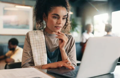 Restaurant professional analyzing financial data on a laptop in a café setting