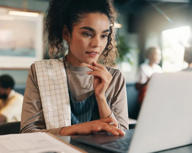 Restaurant professional analyzing financial data on a laptop in a café setting