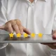 Hands tapping a five-star rating on a tablet.