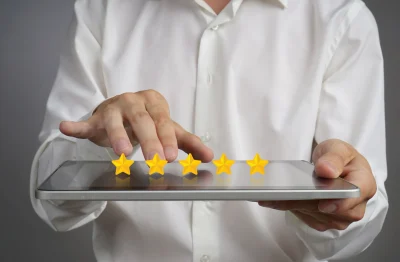 Hands tapping a five-star rating on a tablet.