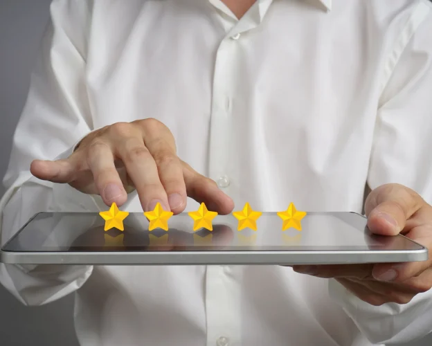 Hands tapping a five-star rating on a tablet.