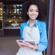 A smiling restaurant employee holding a tablet