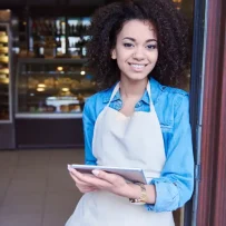 A smiling restaurant employee holding a tablet