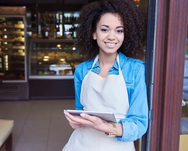 A smiling restaurant employee holding a tablet