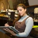 Restaurant employee reviewing financial reports at the counter of a multi-unit restaurant