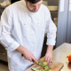 Cook cutting vegetables in restaurant kitchen