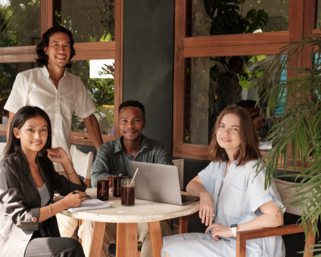 Restaurant Owners Smiling At Camera in Empty Restaurant with Laptop
