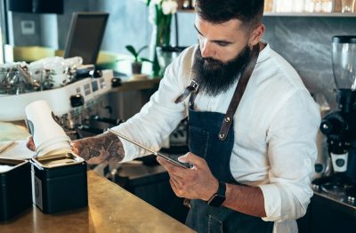 Barista doing an inventory of the products in a cafe