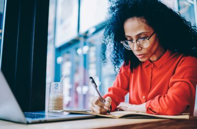 Businesswoman doing financial reporting sitting at laptop computer.