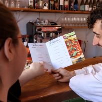 Wait staff advises customer on menu.