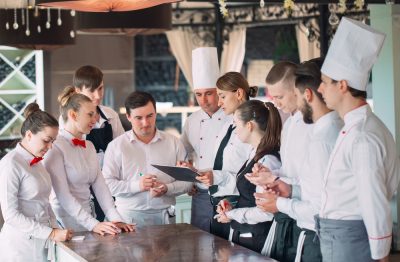 A group of restaurant staff optimizes restaurant operations as a team effort.