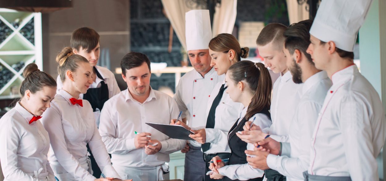 A group of restaurant staff optimizes restaurant operations as a team effort.