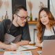 Two restaurant owners using a laptop discussing finances at a cafe