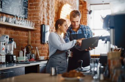 Two restaurant owners discussing menu pricing.