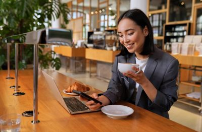 Young,Asian,Business,Woman,Wearing,Suit,Drinking,Coffee,Using,Smartphone