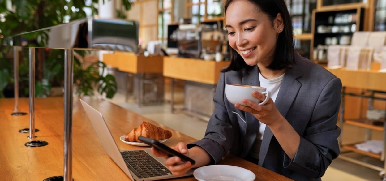 Young,Asian,Business,Woman,Wearing,Suit,Drinking,Coffee,Using,Smartphone